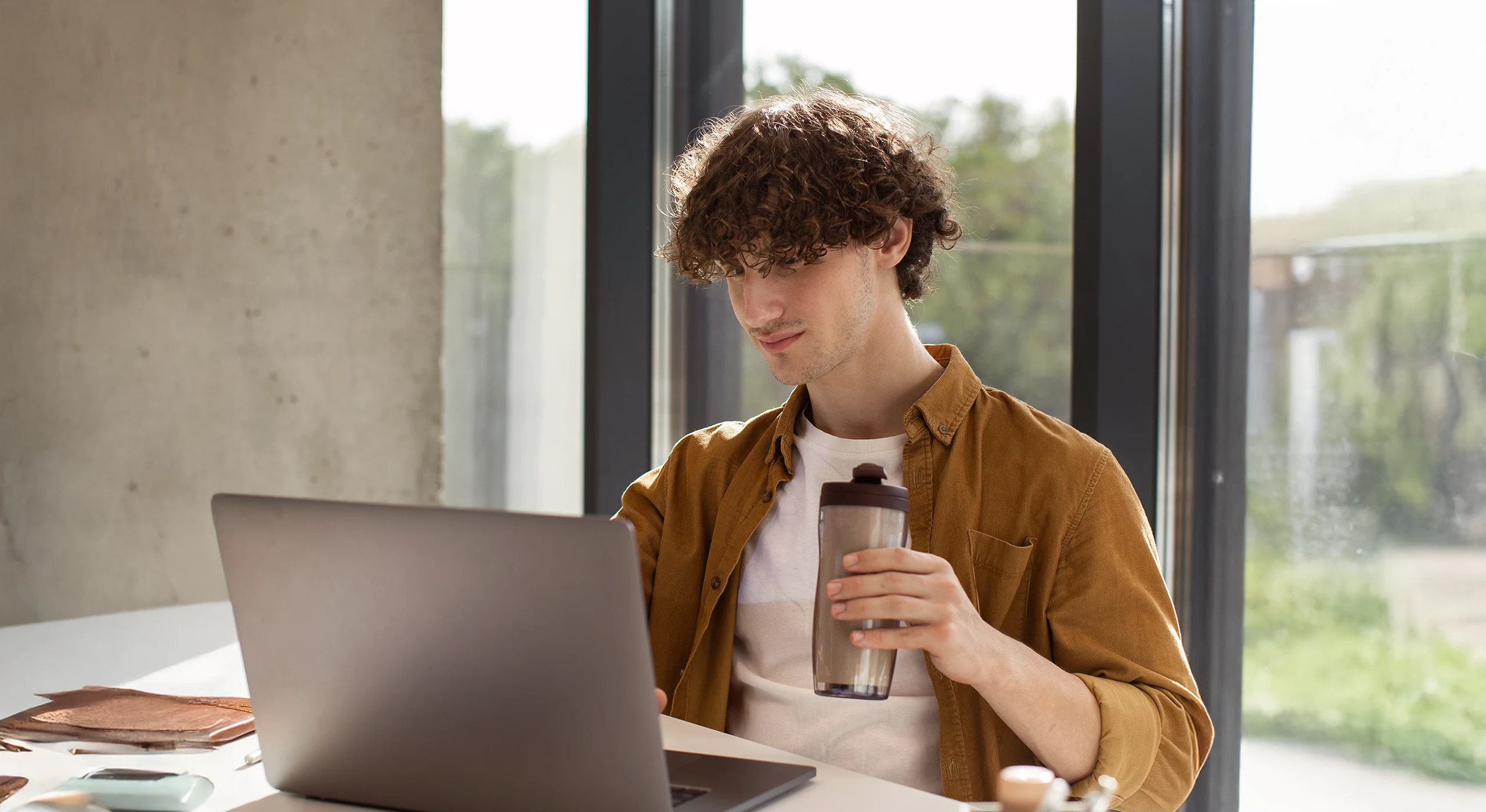Joven estudiando con los cursos online de la academia de oposiciones SKR desde su portátil.