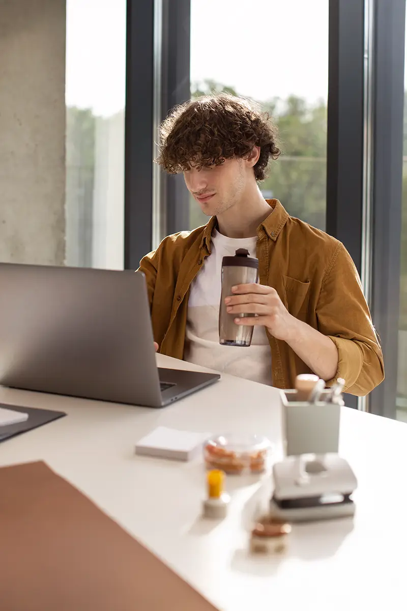 Joven estudiando con los cursos online de la academia de oposiciones SKR desde su portátil.