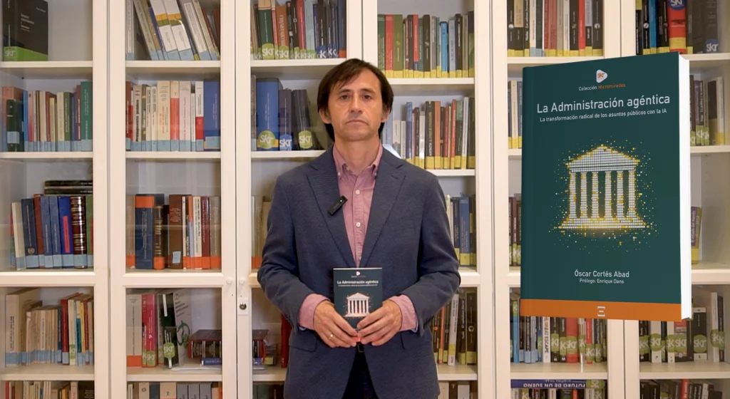 óscar cortés sosteniendo un ejemplar de su libro la administración agéntica junto a la portada ampliada de la obra.