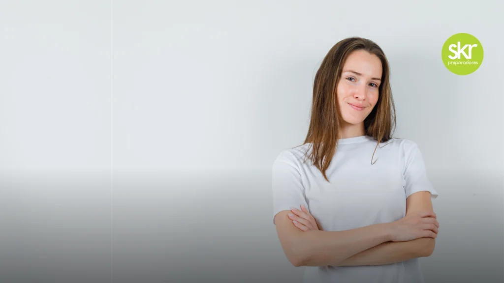 mujer joven sonriente con los brazos cruzados junto al logotipo verde de skr preparadores, ilustrando el éxito de los alumnos en el examen de gestión del estado.